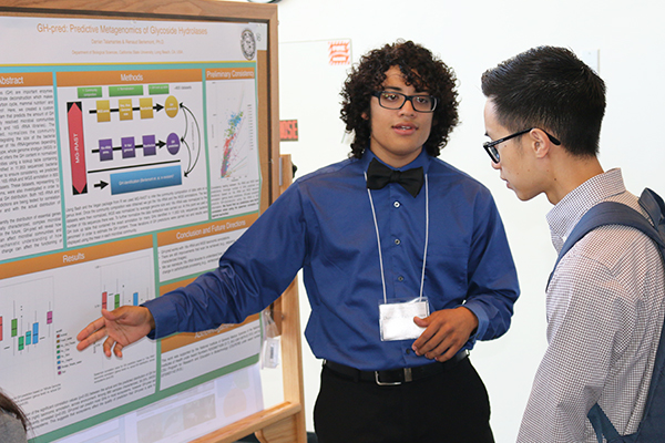 student researcher explaining his research to a student