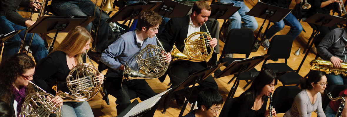 Closeup of French horn players in concert.