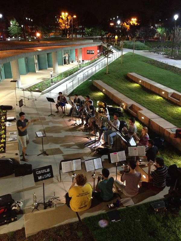 The University Brass Ensemble performing in the Bob Cole Amphitheatre at night.