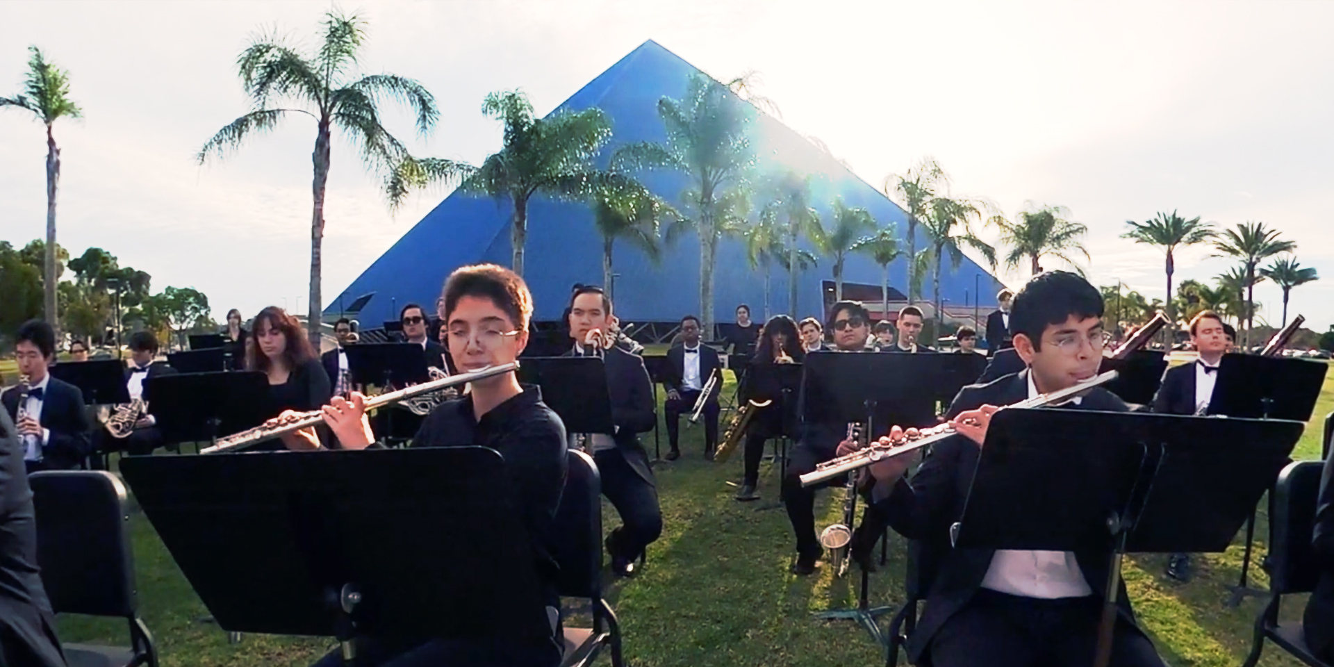 Bob Cole Conservatory Wind Symphony outside on the lawn in front of the Pyramid.