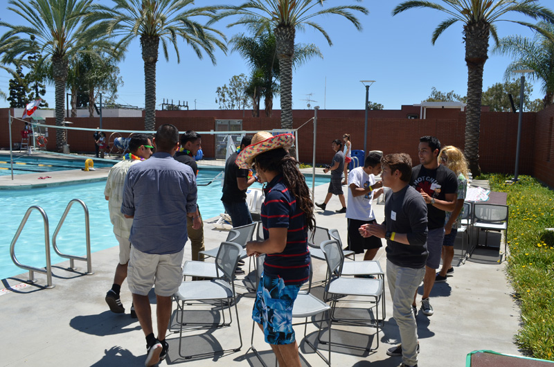 students playing musical chairs poolside