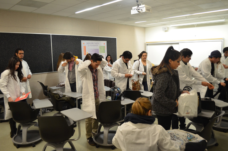 students broaching lab coats